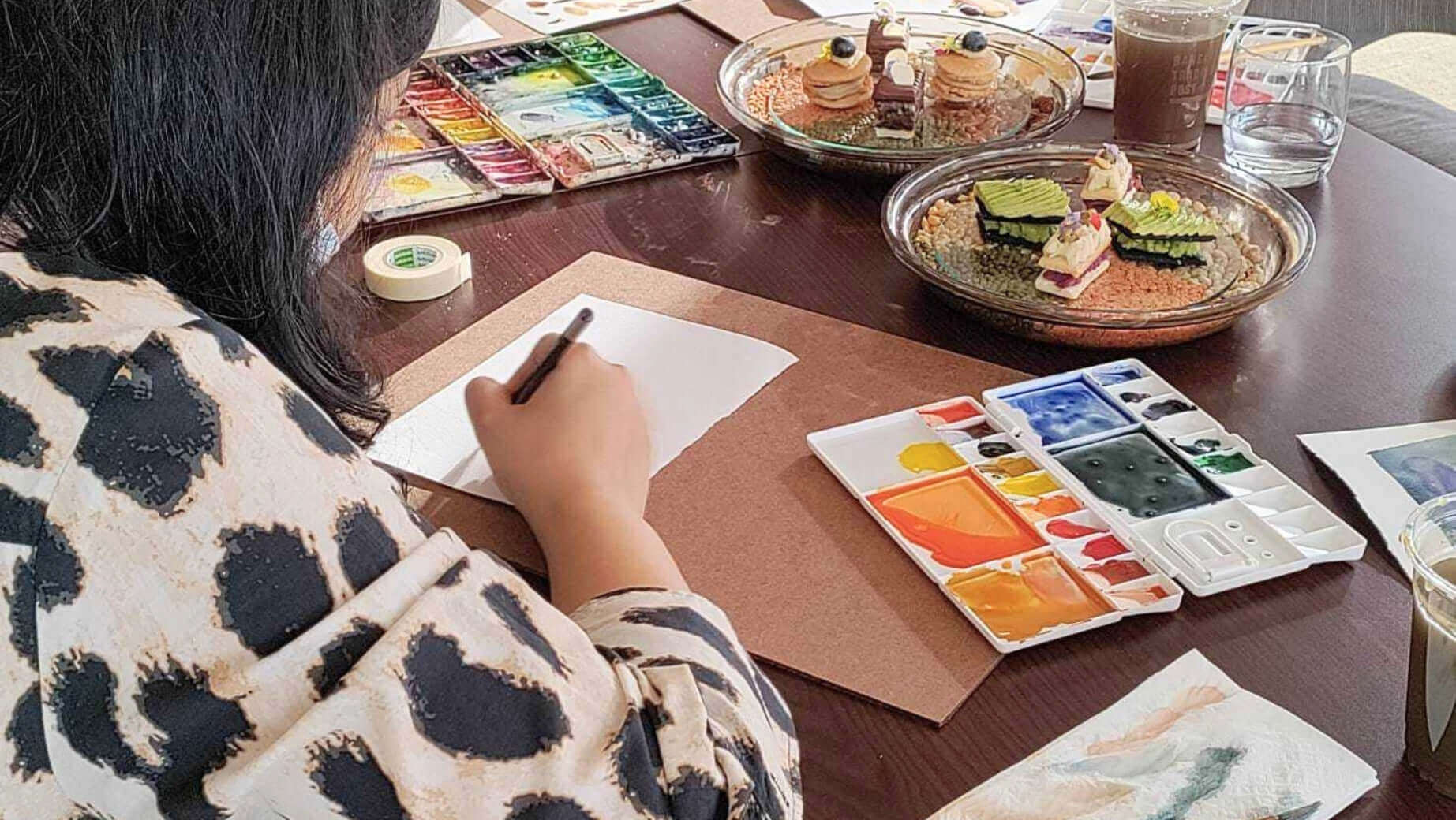 Person painting with watercolours at Supmanee’s workshop.