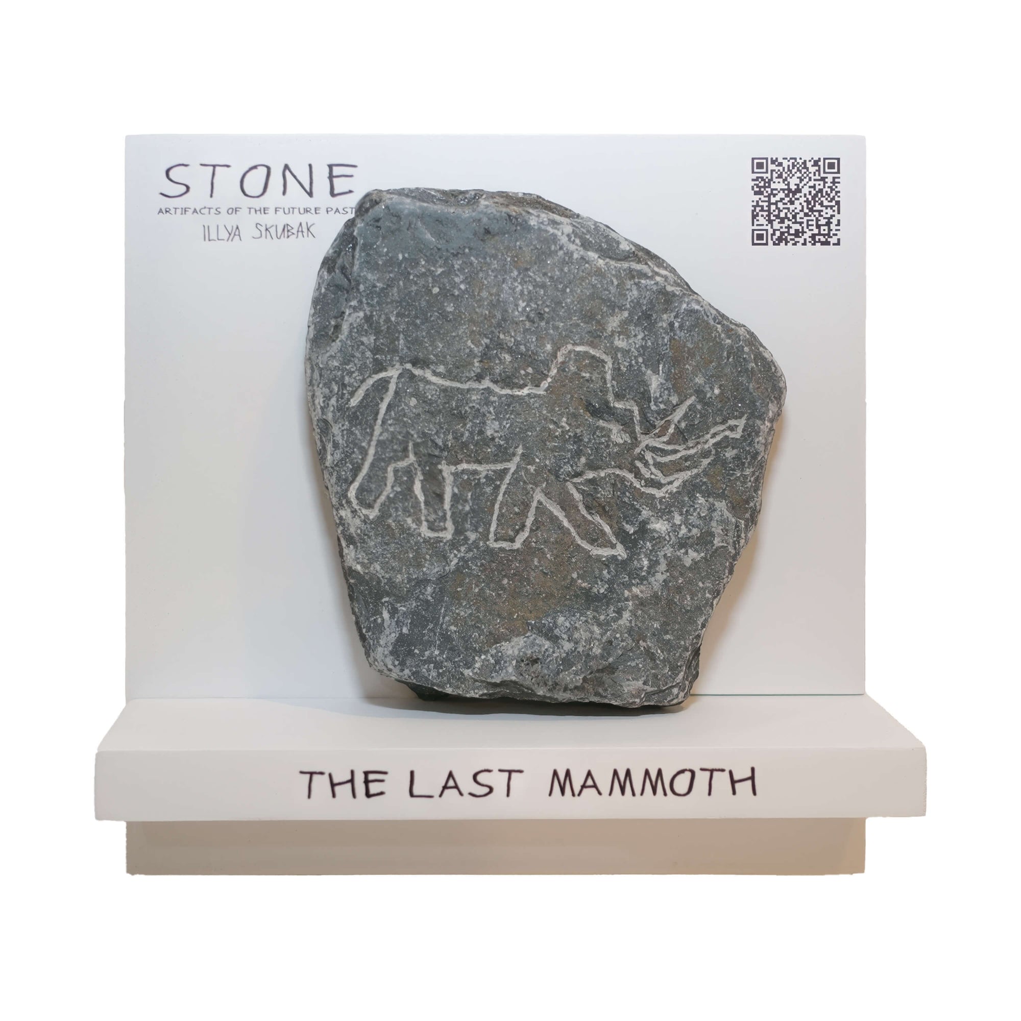 Stone artifact titled 'The Last Mammoth' featuring carved mammoth design, displayed on a white stand.