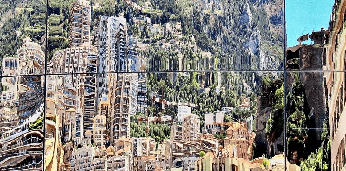 Reflection of modern buildings in a mirrored surface with a mountainous backdrop in Monaco.