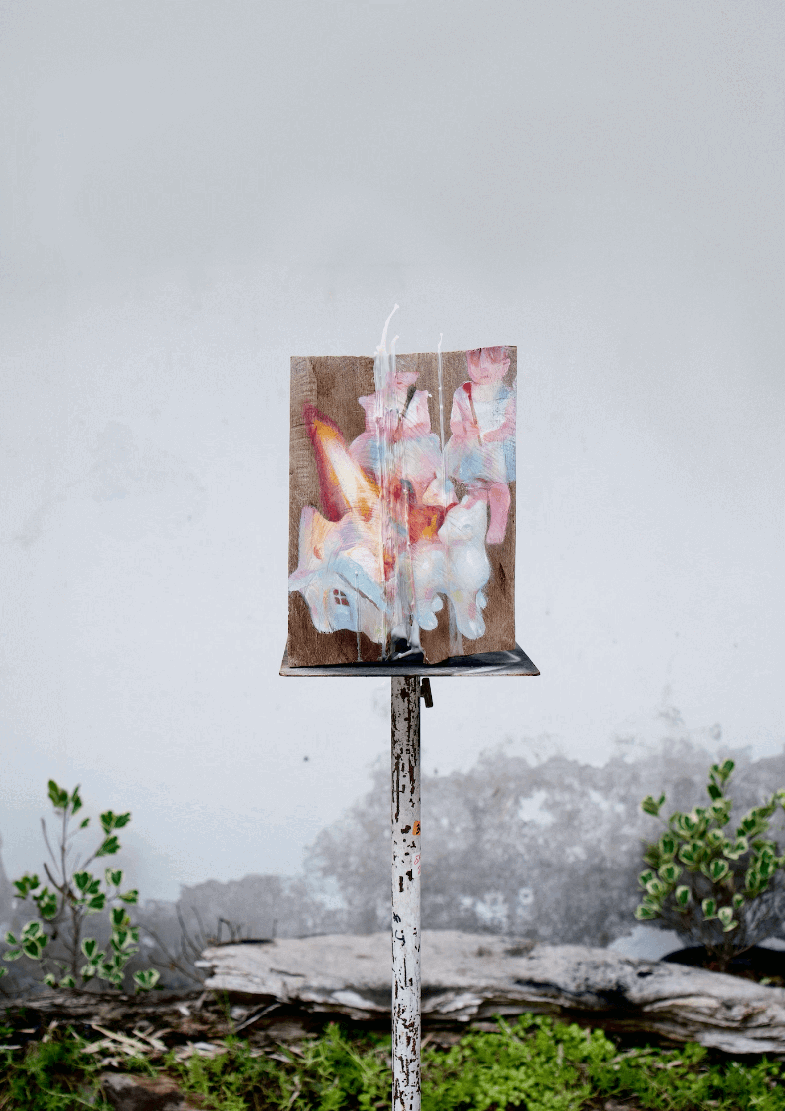 Vibrant pastel artwork on outdoor display stand against urban background with greenery.
