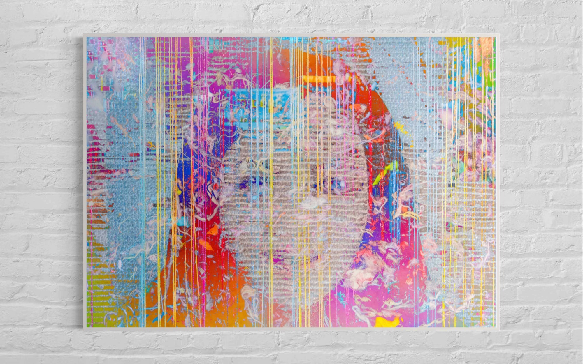 Colourful abstract painting on a white brick wall.