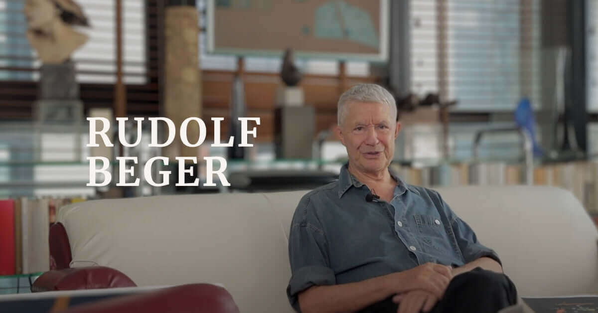 Rudolf Beger sitting comfortably in a creative workspace, embodying artistic transformation and personal growth.