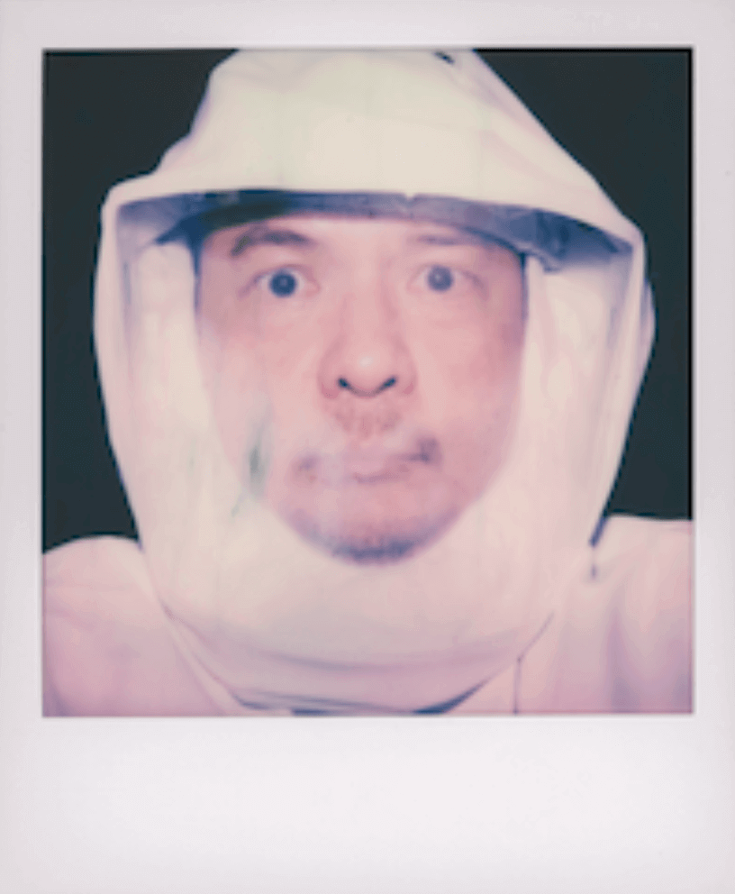 Portrait of a person in a white hooded suit.