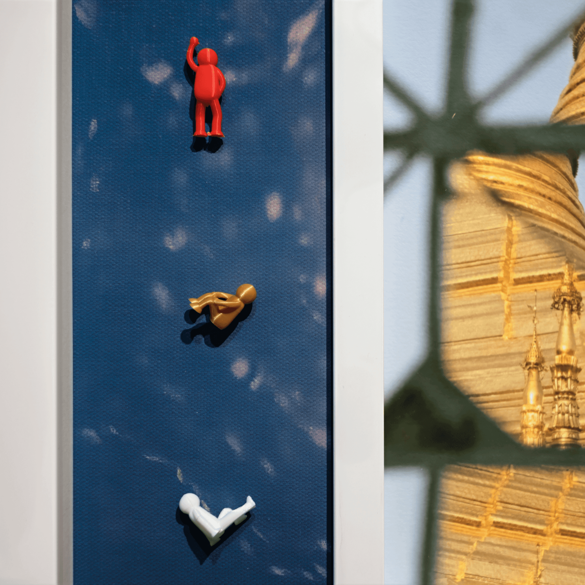 Continous Line, 2025 features colorful figures climbing on a blue surface with a golden background.