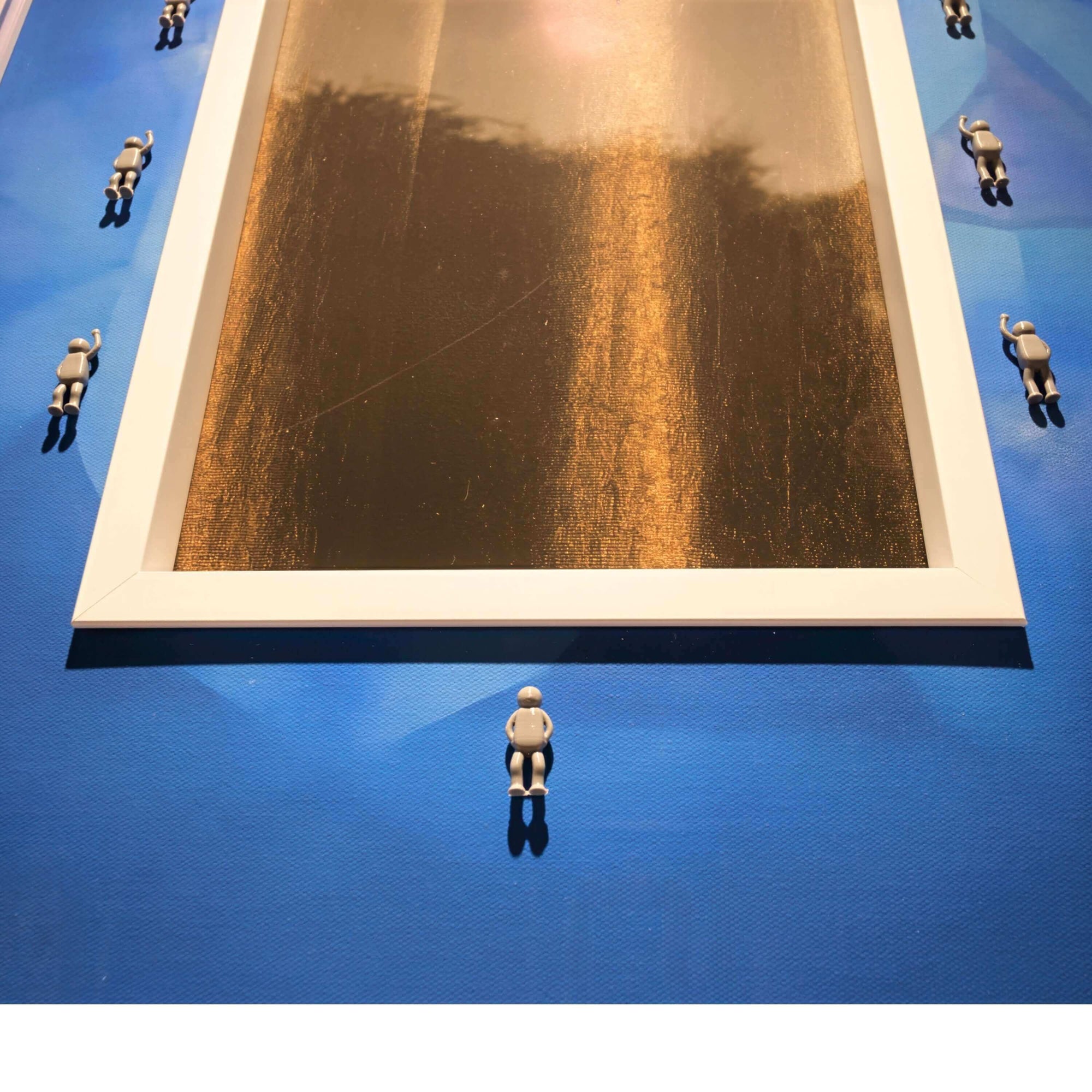 Art installation featuring miniature figures surrounding a central golden frame, titled Rhythm of the Frame, 2025.
