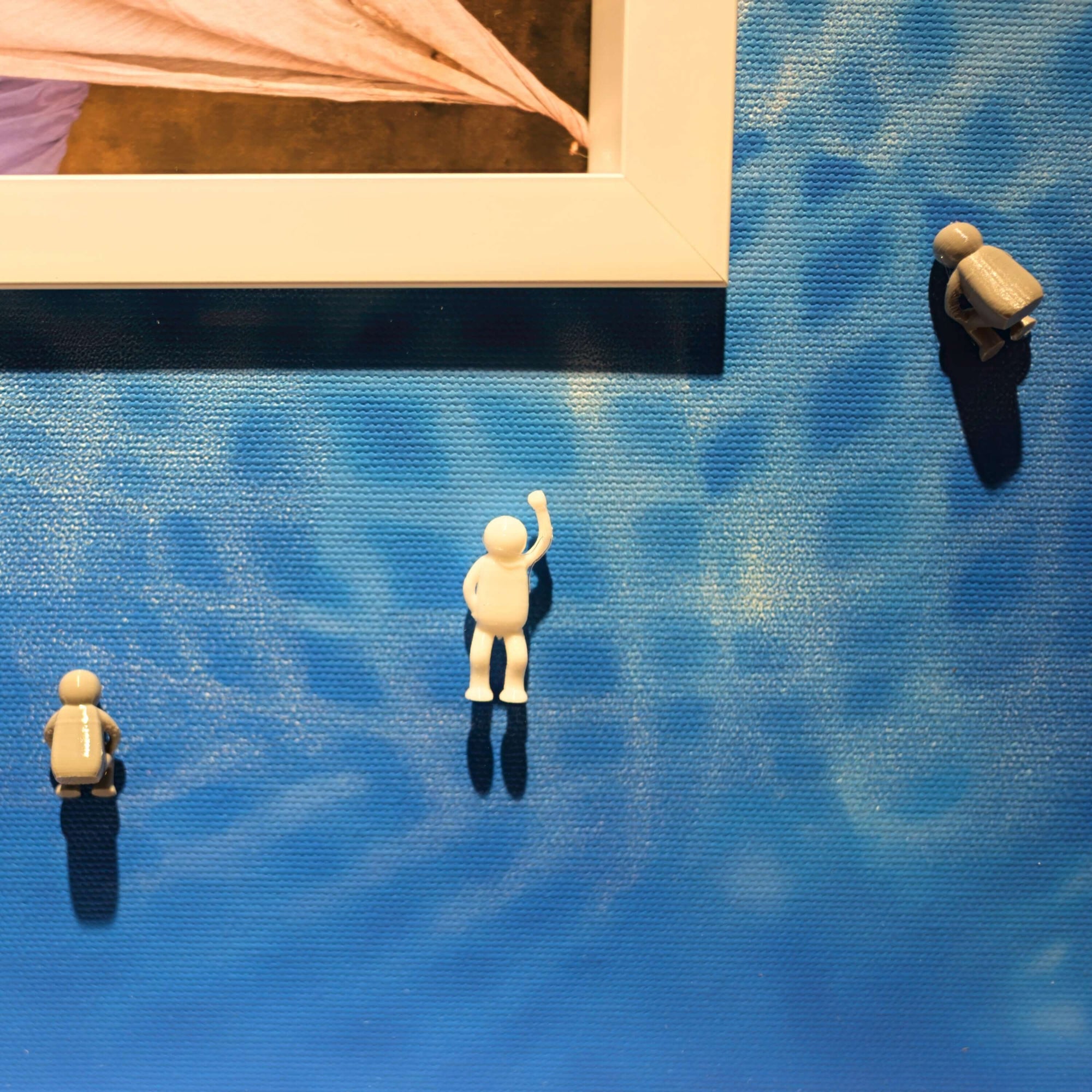 Covered Memory, 2025 figurines on a blue canvas background, showcasing a creative art display.