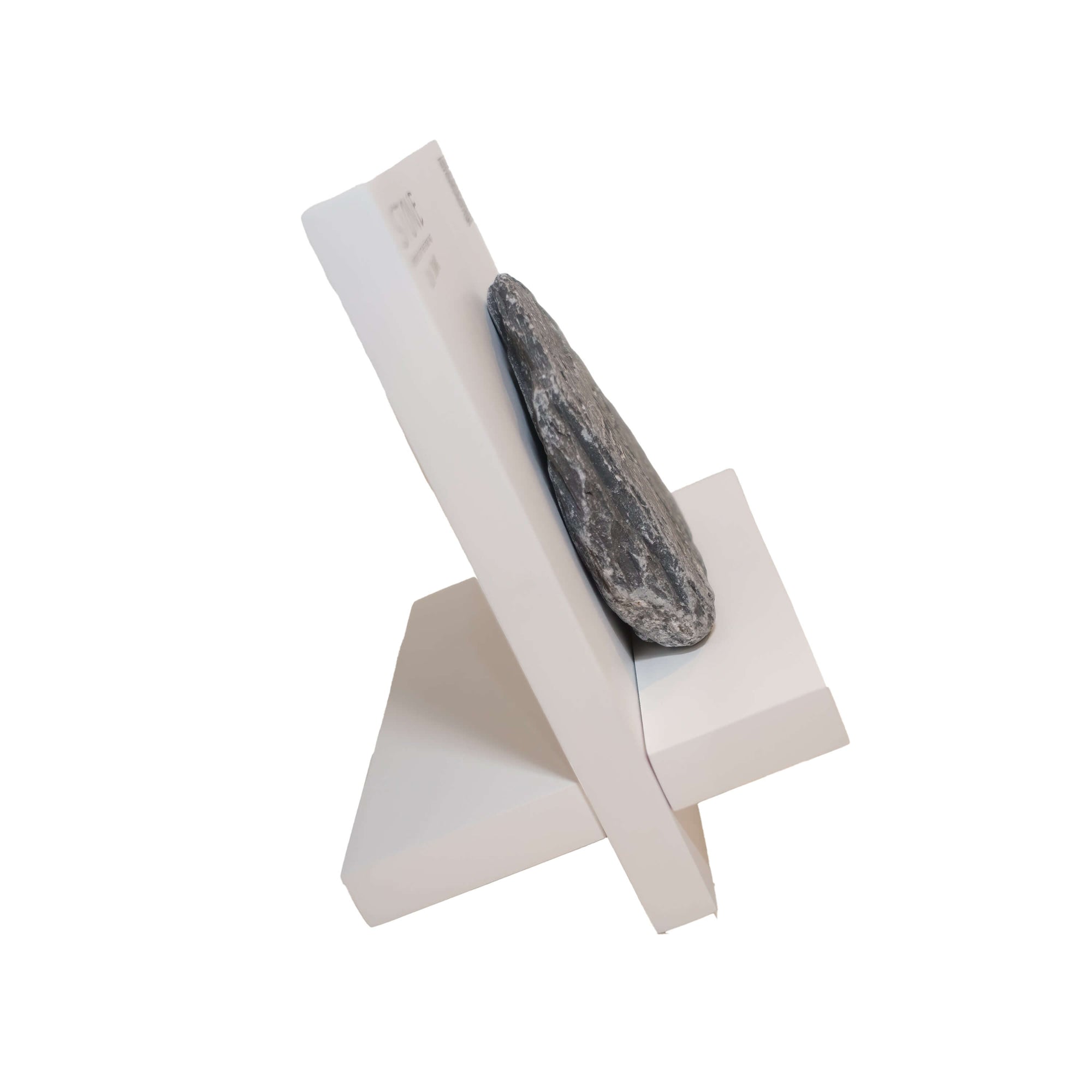 Minimalist book holder with a natural stone on a white stand, showcasing a unique blend of art and functionality.
