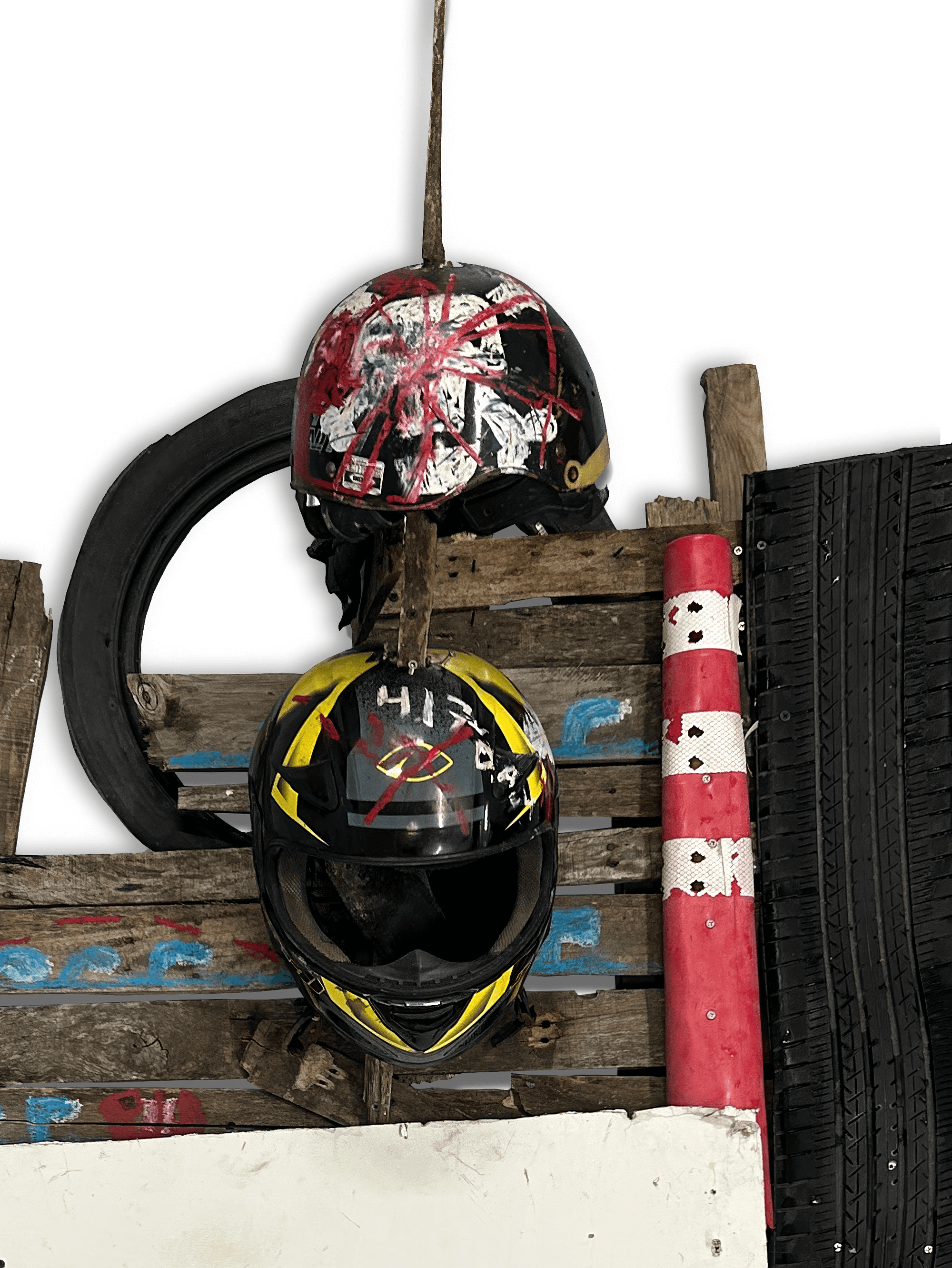 Two colorful helmets displayed on a wooden wall with tire and pole elements, showcasing a racing theme.