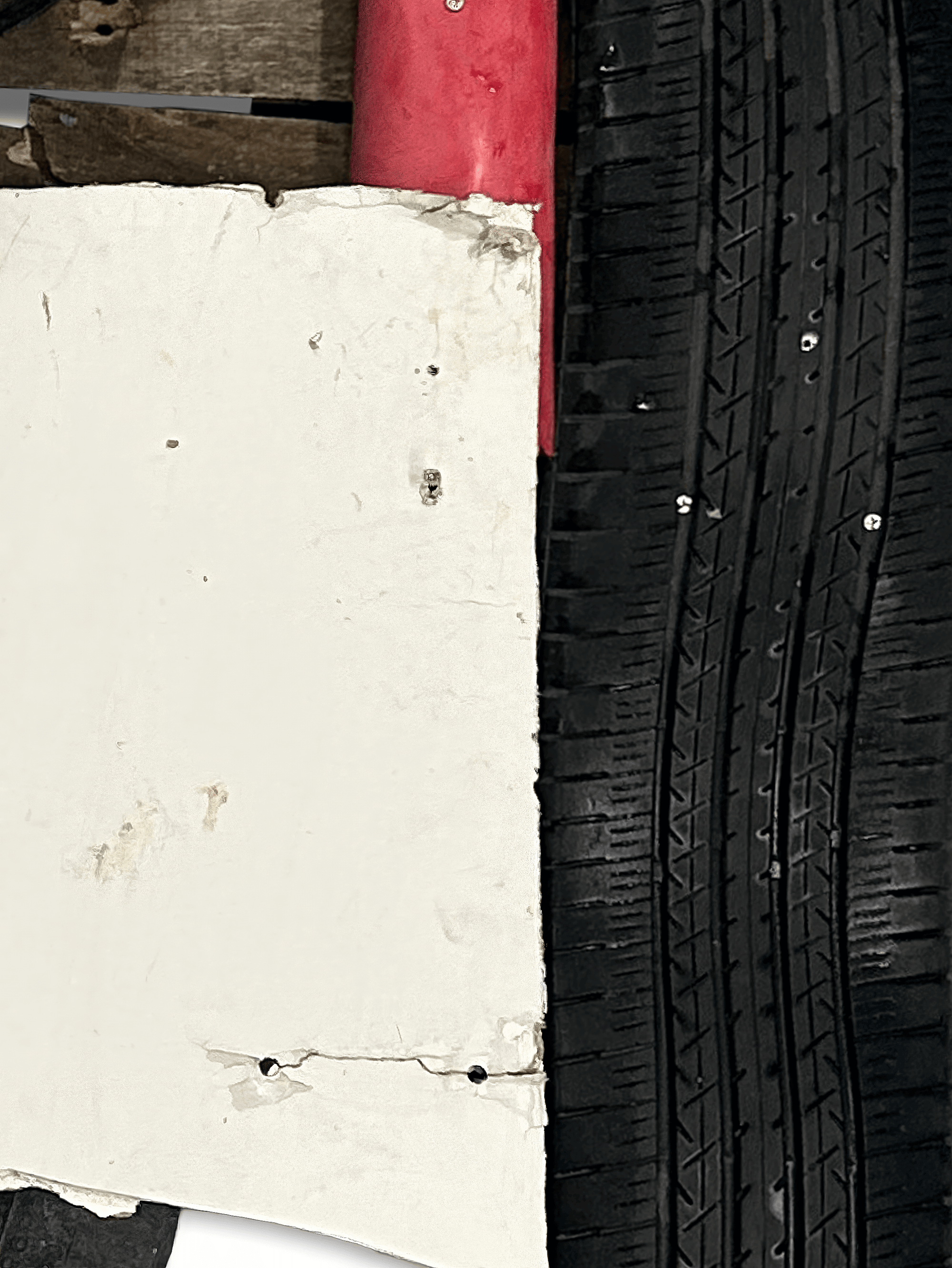 Close-up of a textured white surface next to a black tire with detailed tread grooves.
