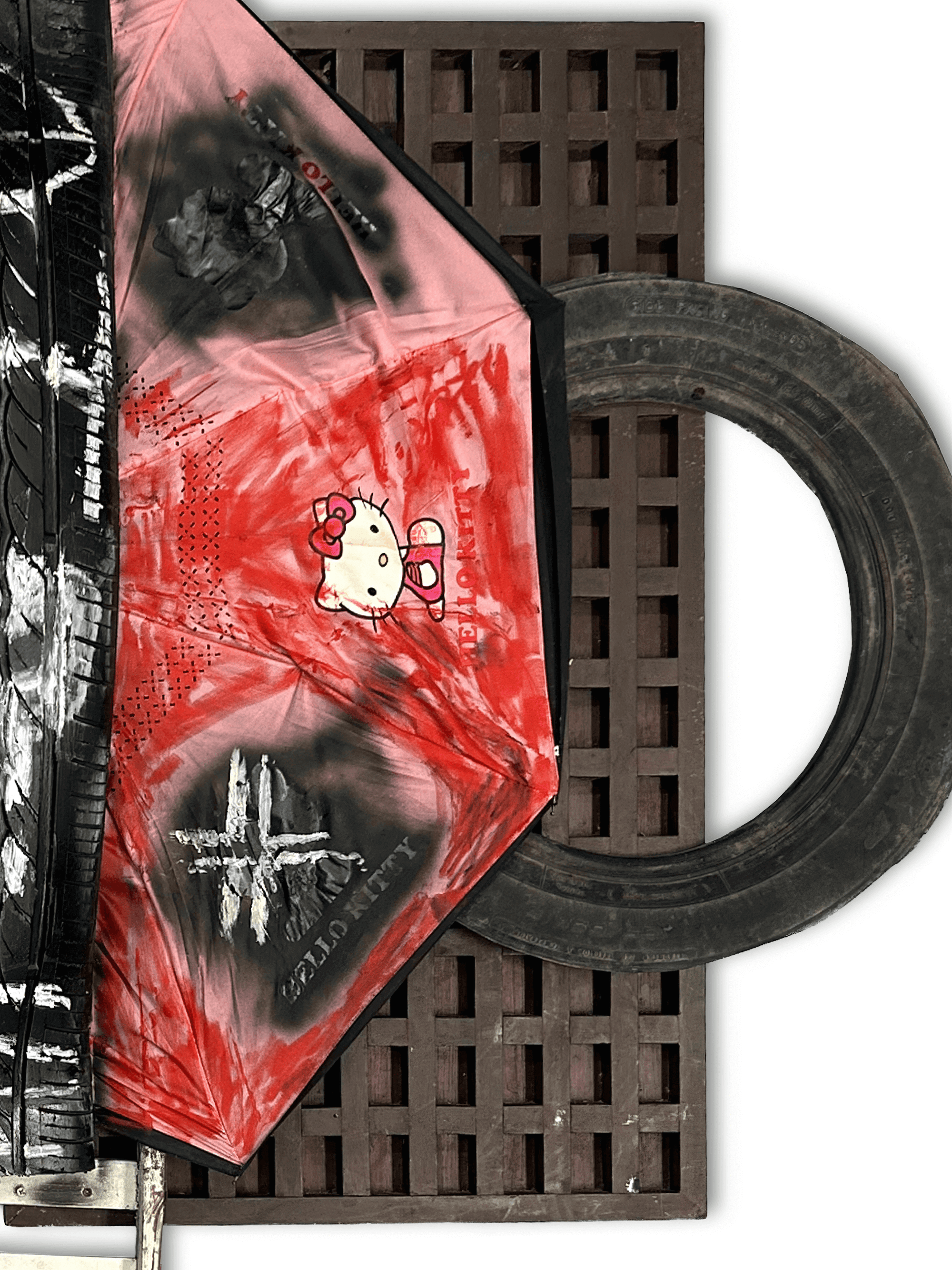 Artistic umbrella featuring Hello Kitty design in reds, placed on a textured surface with a black tire.
