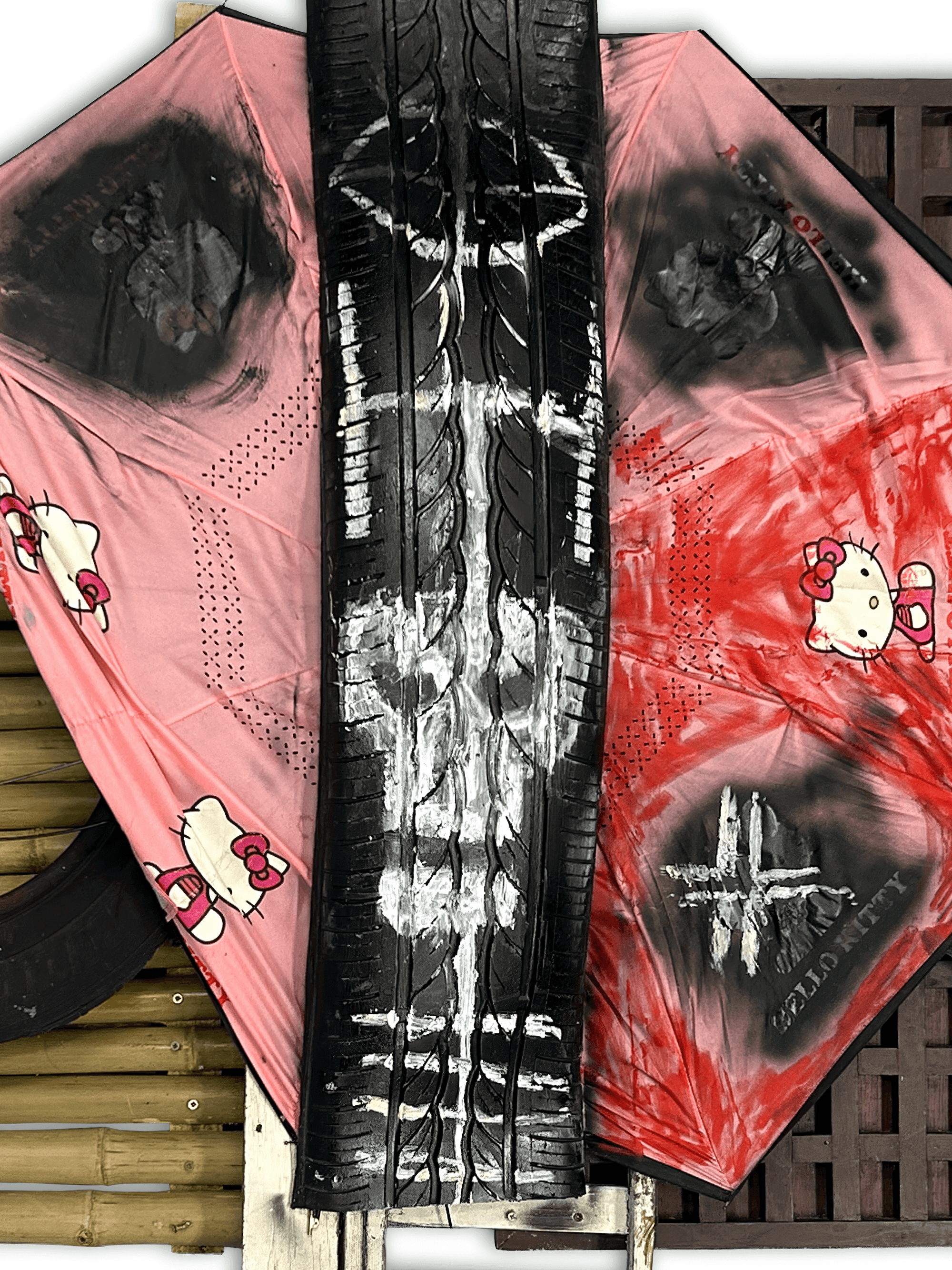 Art installation featuring a tire and fabric painted with Hello Kitty designs and abstract patterns, blending pop culture with artistic expression.