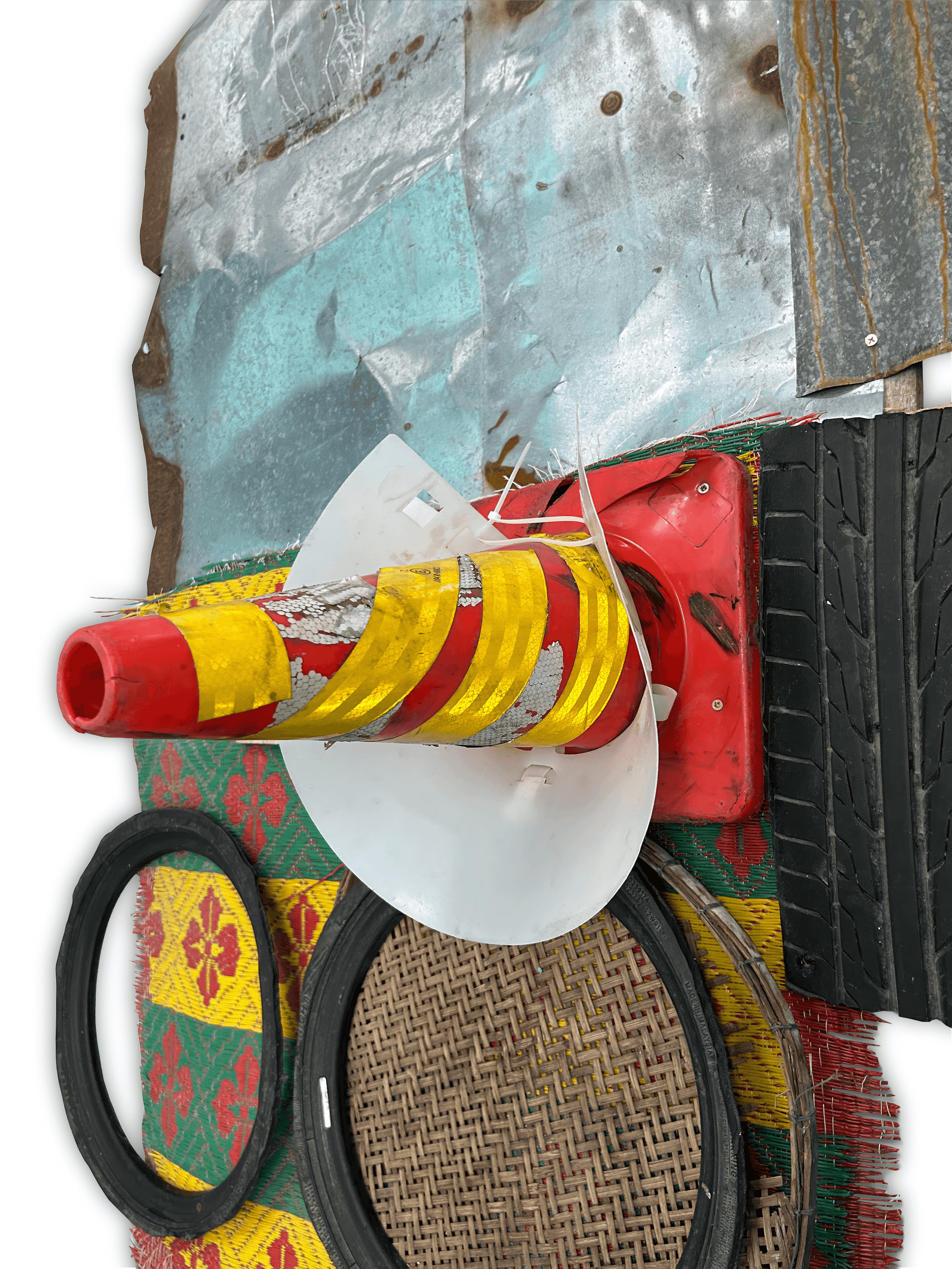 Abstract artwork featuring layered materials, including metal, fabric, and rubber with bright colors and textures, showcasing contemporary recycling art.