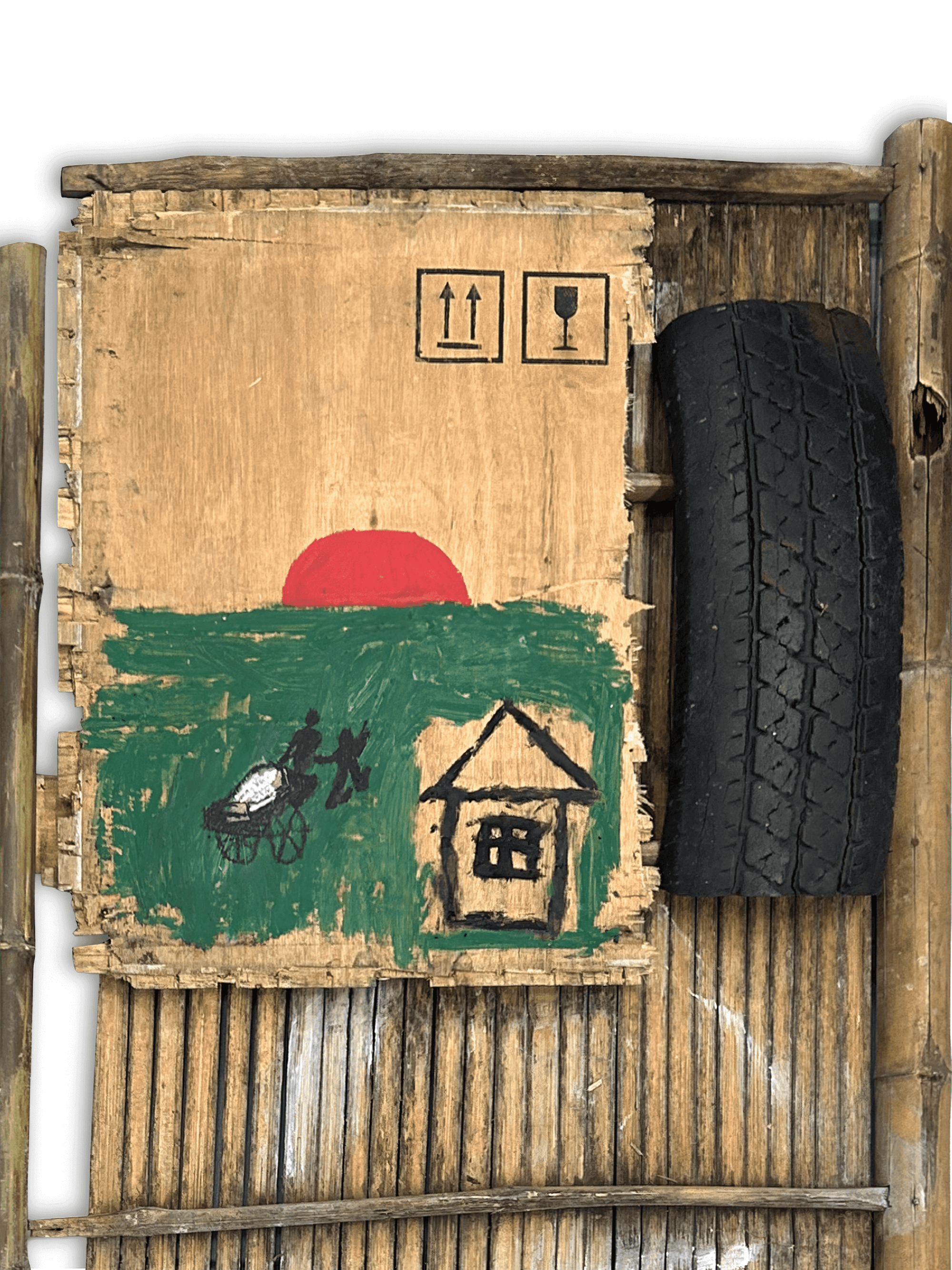 Artistic cardboard piece depicting a sunset, a house, and a figure with a cart, accompanied by a tire.